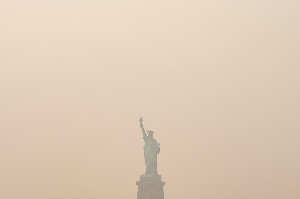 The Statue of Liberty is photographed from the Staten Island Ferry as smoke from wildfires blankets the sky, Thursday, July 16, 2026, in New York. (AP Photo/Yuki Iwamura)