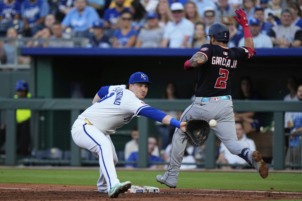 Washington Nationals' Luis Garcia Jr. (2) is out at first by Kansas City Royals first baseman Vinnie Pasquantino after bunting during the third inning of a baseball game, Tuesday, Aug. 12, 2025, in Kansas City, Mo. (AP Photo/Charlie Riedel)