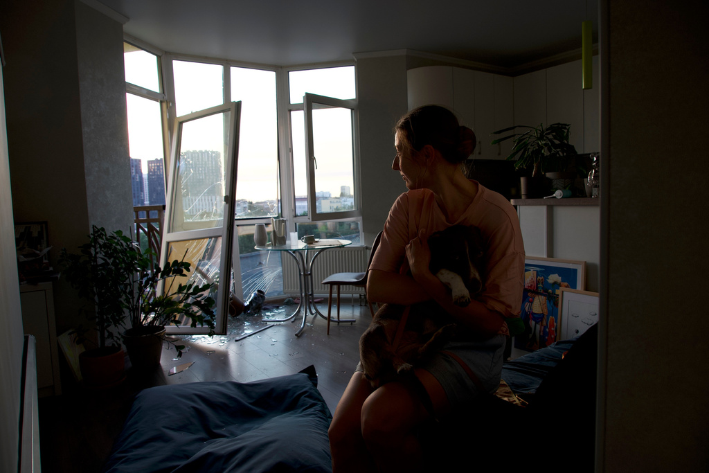 Julia Sosnovska hugs her dog Perry inside her apartment in the Lukianivka neighbourhood of Kyiv, Ukraine, Sunday, July 19, 2026, the morning after it was damaged by a Russian attack. (AP photo/Vasilisa Stepanenko)