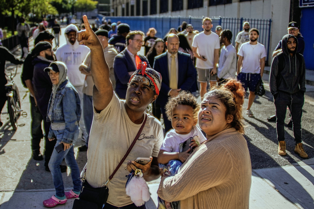 People take a look at part of a building that collapsed in the Bronx borough of New York, Wednesday, Oct. 1, 2025. (AP Photo/Eduardo Munoz Alvarez)