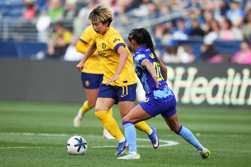 Utah Royals forward Mina Tanaka (11) moves the ball against Seattle Reign FC midfielder Samantha Meza (20) during the first half of an NWSL soccer match, Sunday, April 26, 2026, in Seattle. (AP Photo/Lindsey Wasson)