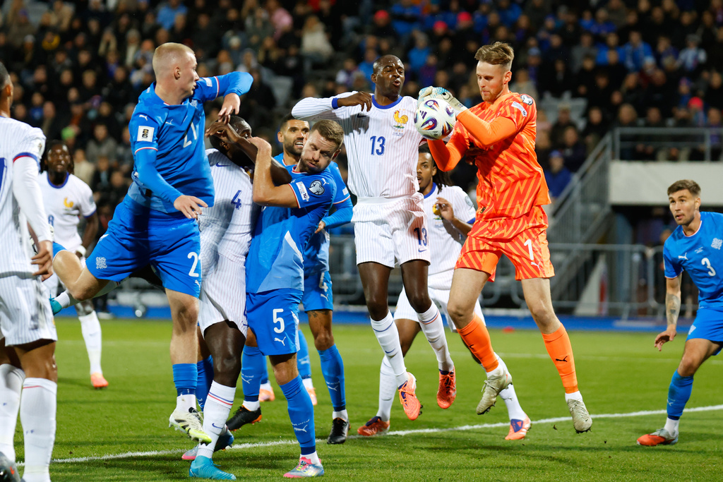 Iceland goalkeeper Elias Rafn Olafsson gets to the ball ahead of France's Jean-Philippe Mateta, center, during a World Cup 2026 group D qualifying soccer match between Iceland and France in Reykjavik, Monday, Oct. 13, 2025. (AP Photo/Brynjar Gunnarsson)