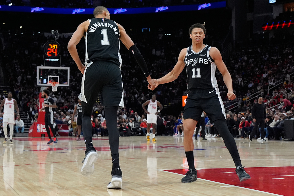 San Antonio Spurs forward Victor Wembanyama (1) celebrates with forward Carter Bryant (11) after scoring against the Houston Rockets during the first half of an NBA basketball game in Houston, Wednesday, Jan. 28, 2026. (AP Photo/Ashley Landis)