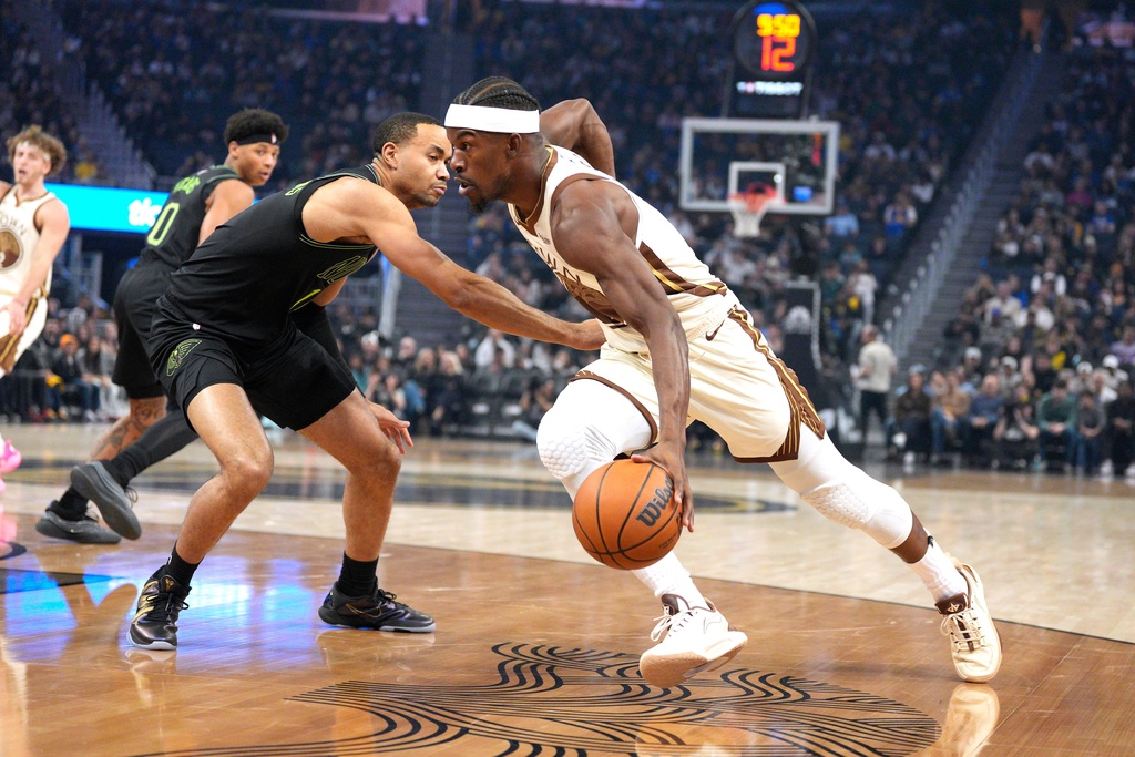 Golden State Warriors forward Jimmy Butler III, right, drives to the basket against New Orleans Pelicans guard Bryce McGowens during the first half of an NBA basketball game in San Francisco, Saturday, Nov. 29, 2025. (AP Photo/Tony Avelar)