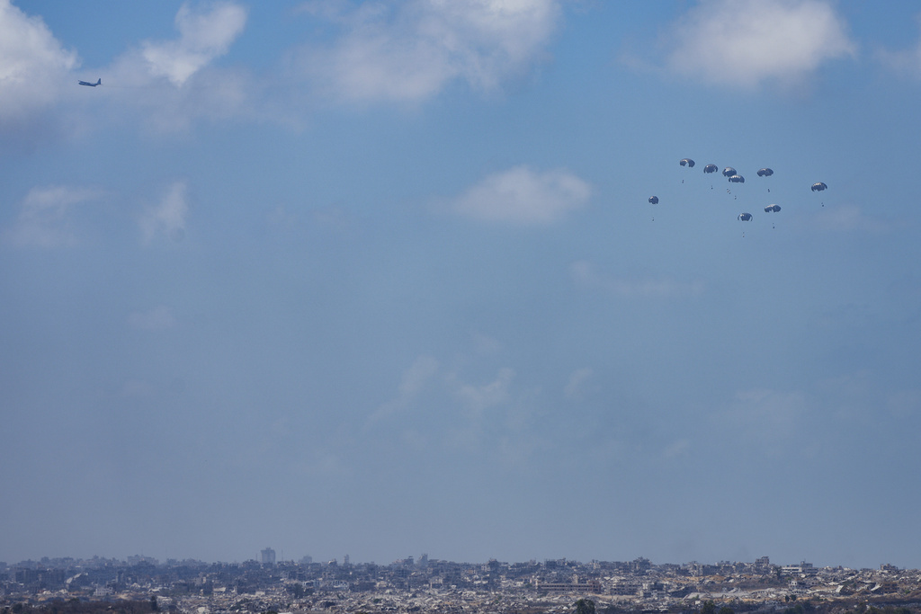 An aircraft airdrops humanitarian aid to Palestinians over Gaza Strip, as seen from southern Israel, Thursday, Aug. 21, 2025. (AP Photo/Maya Levin)