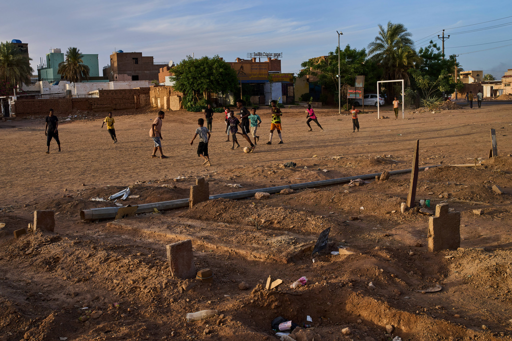 Children play soccer in a public park next to an improvised graveyard from the war in Omdurman, on the outskirts of Khartoum, Sudan, Thursday, April 23, 2026. (AP Photo/Bernat Armangue)