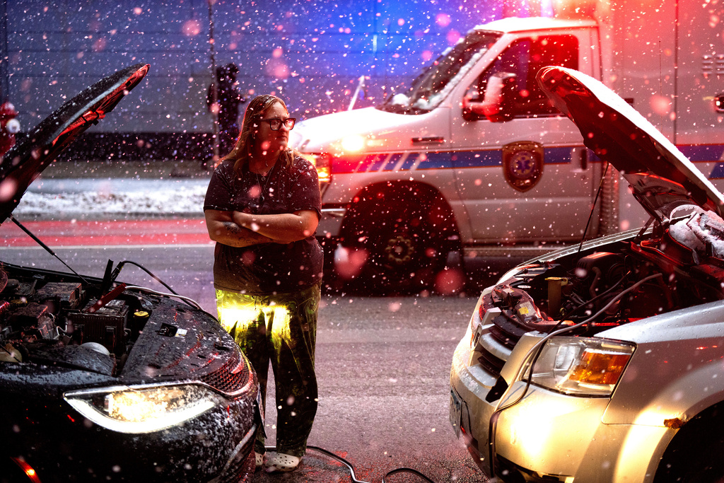 Devon Jordan, of Brainerd , helps a person start their car durning heavy snow fall on Sunday, Dec. 28, 2025 in downtown Minneapolis. (Jerry Holt /Star Tribune via AP)