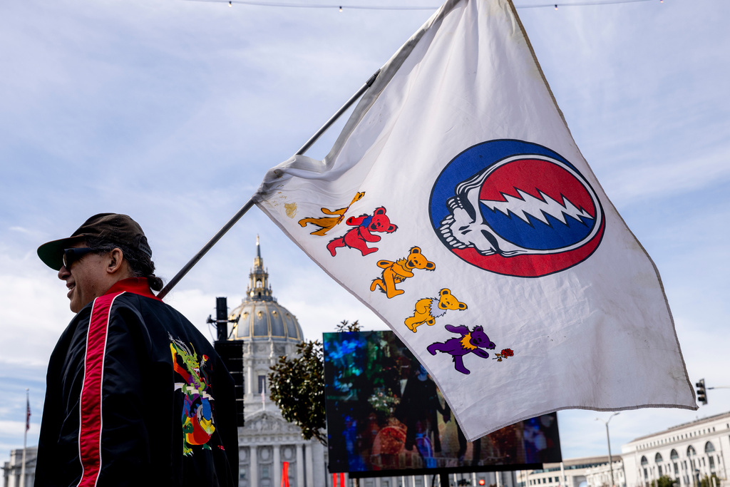 An attendee waves a flag during a public memorial for Grateful Dead co-founder Bob Weir at Civic Center Plaza in San Francisco, Saturday, Jan. 17, 2026. (Stephen Lam/San Francisco Chronicle via AP)