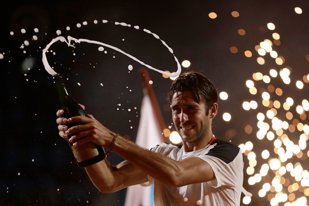 Argentina's Tomas Etcheverry pops champagne to celebrate his victory over Chile's Alejandro Tabilo in the singles final match at the Rio Open tennis tournament in Rio de Janeiro, Sunday, Feb. 22, 2026. (AP Photo/Bruna Prado)