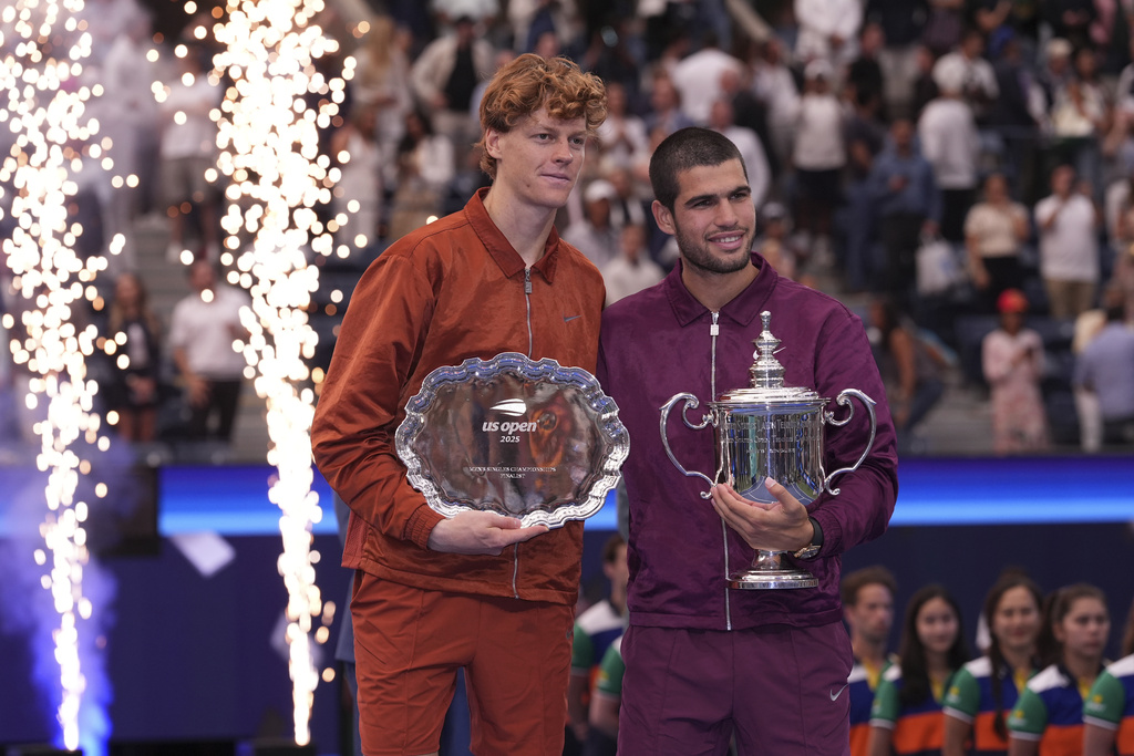 Jannik Sinner, of Italy, left, and Carlos Alcaraz, of Spain, right, hold their trophies after Alcaraz defeated Sinner to win the men's singles final of the U.S. Open tennis championships, Sunday, Sept. 7, 2025, in New York. (AP Photo/Frank Franklin II)