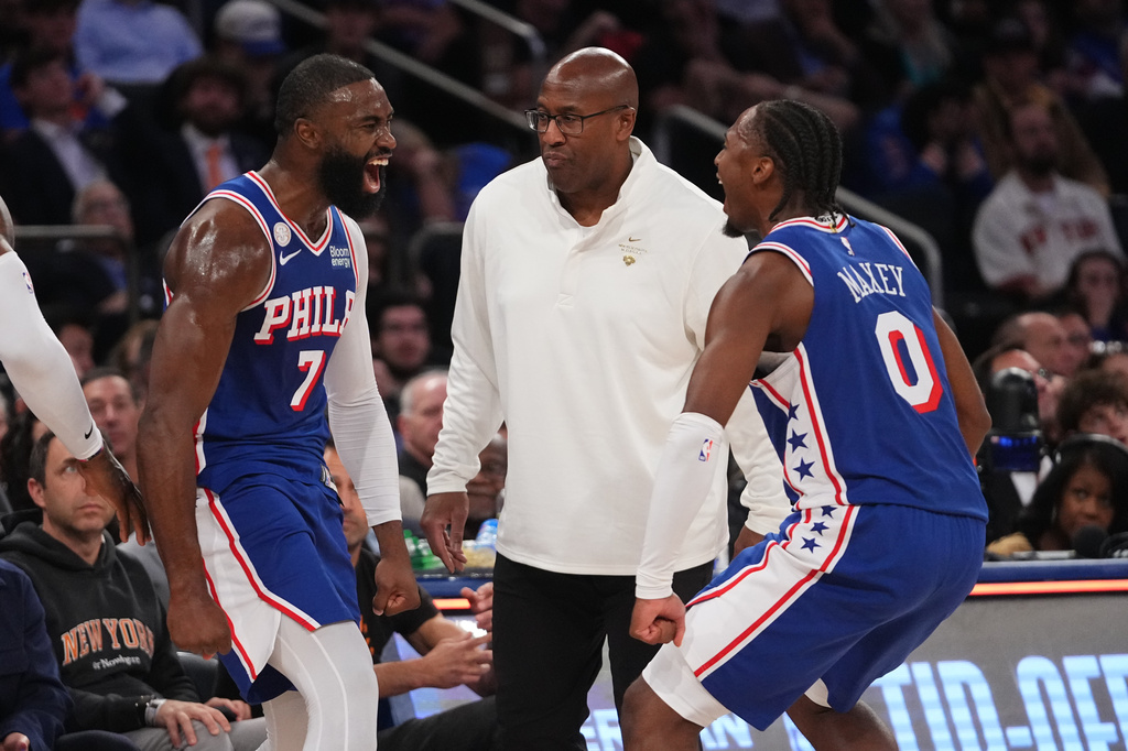 Philadelphia 76ers guard Jaylen Brown, left, celebrates a three-point basket with teammate guard Tyrese Maxey, right, as New York Knicks head coach Mike Brown looks on, center, during the second half of an NBA basketball game Tuesday, Oct. 20, 2026, in New York. (AP Photo/Frank Franklin II)