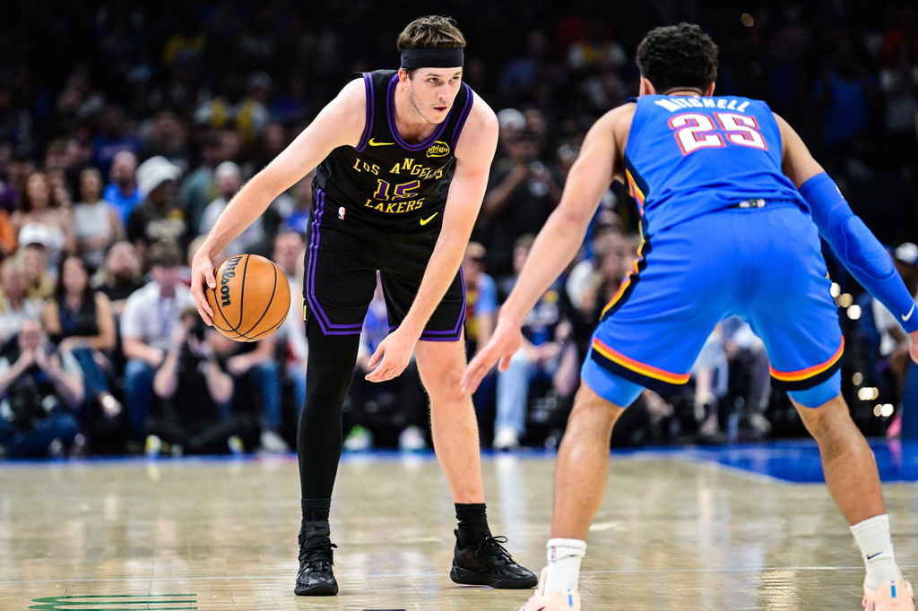 Los Angeles Lakers guard Austin Reaves (15) drives against Oklahoma City Thunder guard Ajay Mitchell (25) during the first half of an NBA basketball game Thursday, April. 2, 2026, in Oklahoma City. (AP Photo/Gerald Leong)