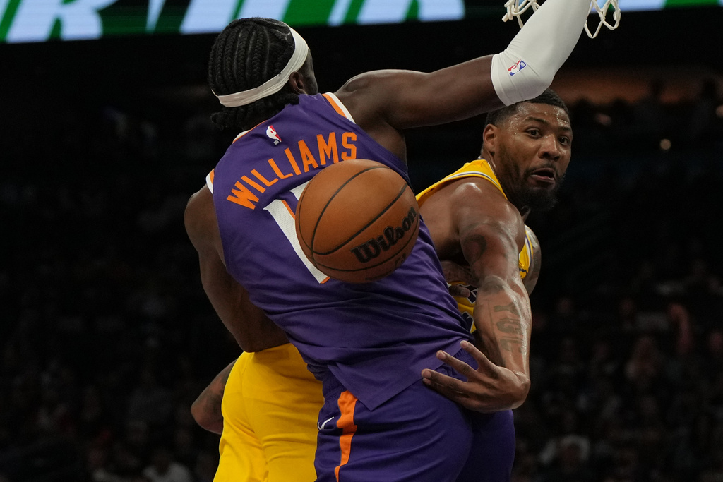 Los Angeles Lakers guard Marcus Smart makes the pass around Phoenix Suns center Mark Williams (15) during the first half of an NBA basketball game, Thursday, Feb. 26, 2026, in Phoenix. (AP Photo/Rick Scuteri)