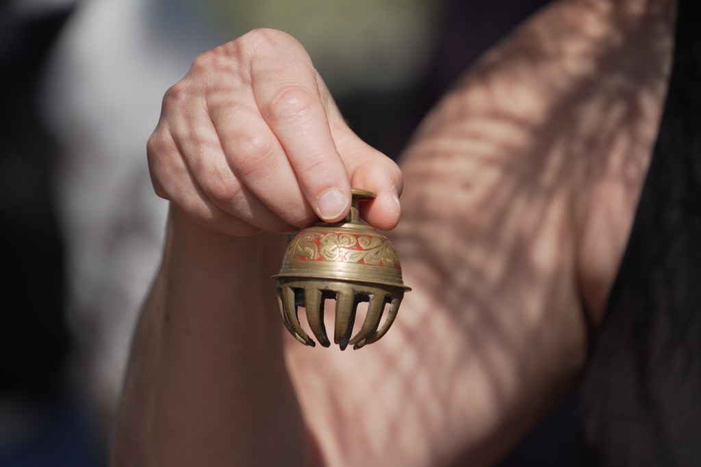 Forest therapy guide Shawn Ramsey rings a tiny brass bell during a "forest bathing" session at the J.C. Raulston Arboretum in Raleigh, N.C., on Sunday, March 22, 2026. (AP Photo/Allen G. Breed)