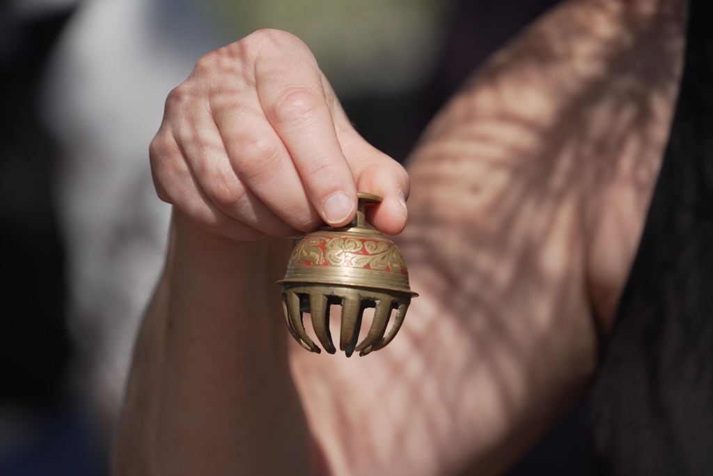 CORRECTS SPELLING TO JC Forest therapy guide Shawn Ramsey rings a tiny brass bell during a "forest bathing" session at the JC Raulston Arboretum in Raleigh, N.C., on Sunday, March 22, 2026. (AP Photo/Allen G. Breed)