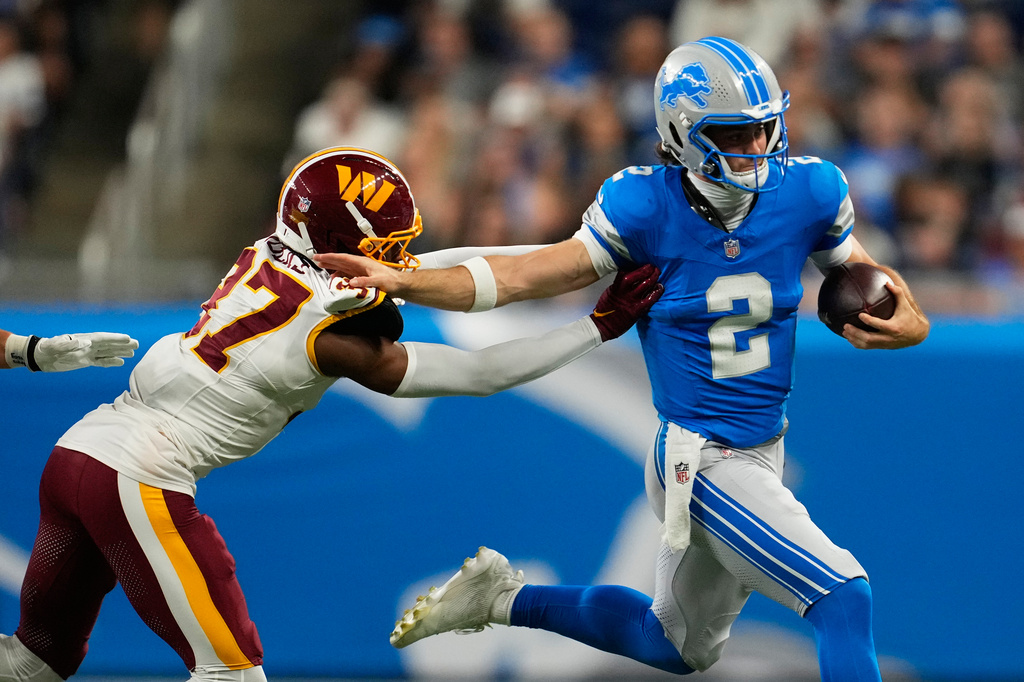 Detroit Lions quarterback Luke Altmyer (2) runs the ball against Washington Commanders Car'lin Vigers (37) during a preseason NFL football game, Saturday, Aug. 22, 2026, in Detroit. (AP Photo/Paul Sancya)
