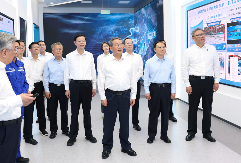 In this photo released by Xinhua News Agency, Chinese Premier Li Qiang, center, listens to enterprise introduction and report on the development of shipbuilding industry in Dalian at the Dalian Shipbuilding Industry Co., Ltd. in Dalian, northeastern China's Liaoning Province on Monday, June 22, 2026. (Huang Jingwen/Xinhua via AP)