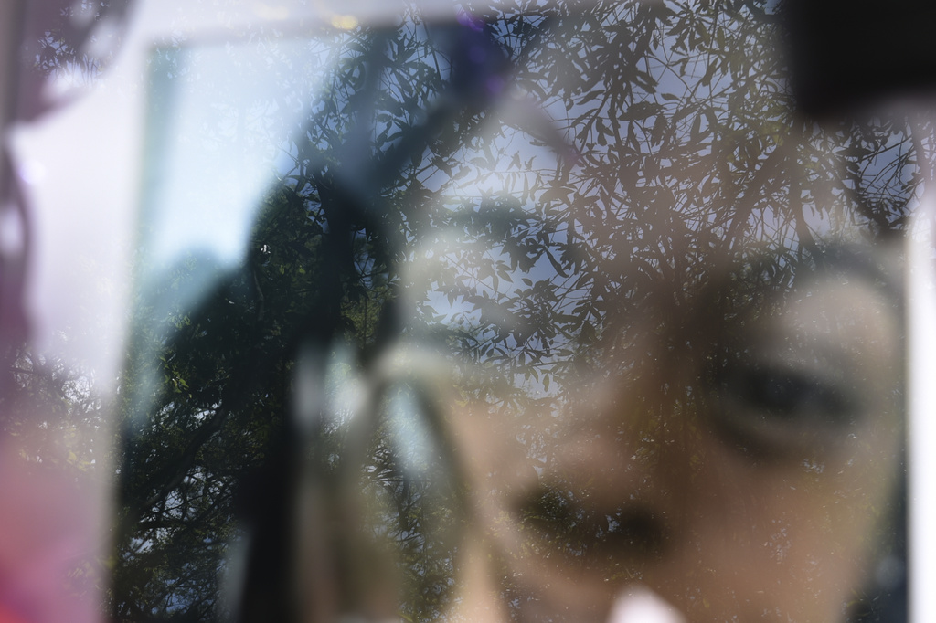 Leaves reflect on the glass of photograph of Tasia Fortune at a makeshift memorial on Monday, Aug. 10, 2026, in Jackson, Miss. (AP Photo/Sophie Bates)
