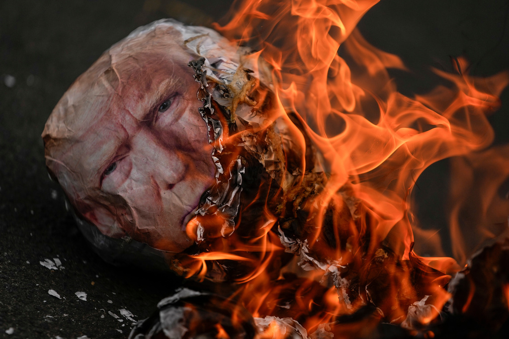 An effigy of U.S. President Donald Trump burns during an International Workers' Day march marking May Day in Panama City, Friday, May 1, 2026. (AP Photo/Matias Delacroix)