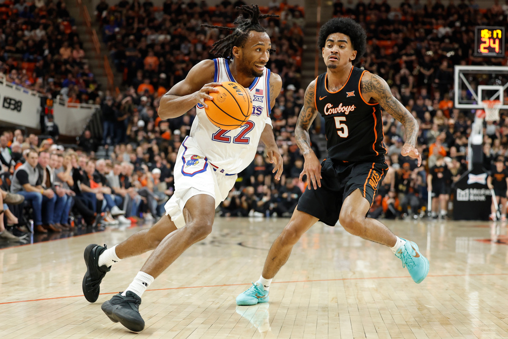 Kansas guard Darryn Peterson (22) drives past Oklahoma State guard Vyctorius Miller (5) during the first half of a NCAA college basketball game Wednesday, Feb. 18, 2026, in Stillwater, Okla. (AP Photo/Alonzo Adams)