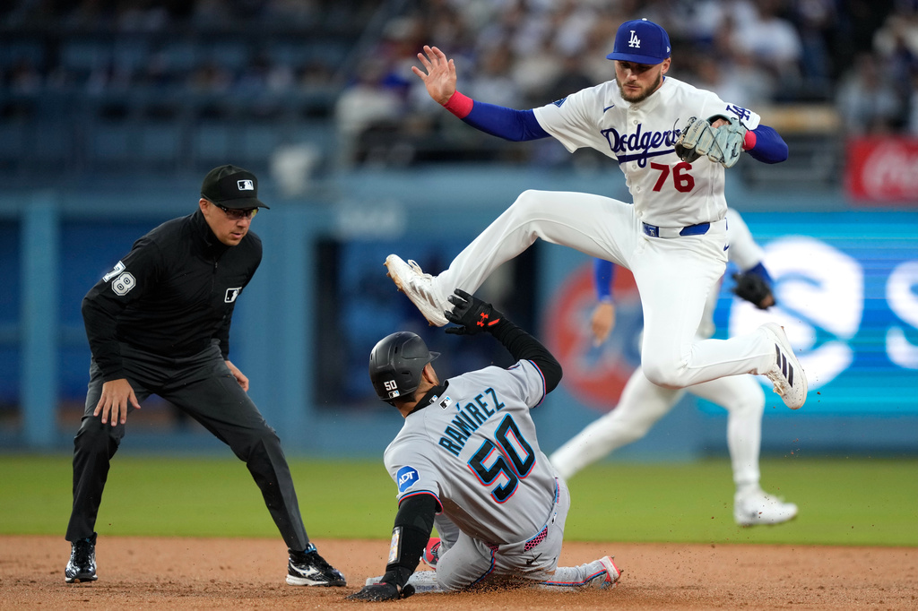 Los Angeles Dodgers shortstop Alex Freeland, right, jumps out of the way after an overthrow by Shohei Ohtani as Miami Marlins' Agustin Ramirez steals second during the second inning of a baseball game Tuesday, April 28, 2026, in Los Angeles. (AP Photo/Mark J. Terrill)