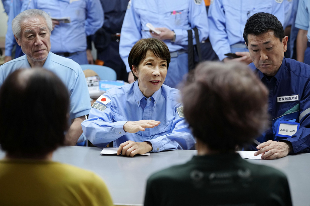 Japan's Prime Minister Sanae Takaichi meets evacuees as she visits an evacuation center in Hikawa, southern Japan, Monday, Aug. 3, 2026. (Japan Pool/Kyodo News via AP)