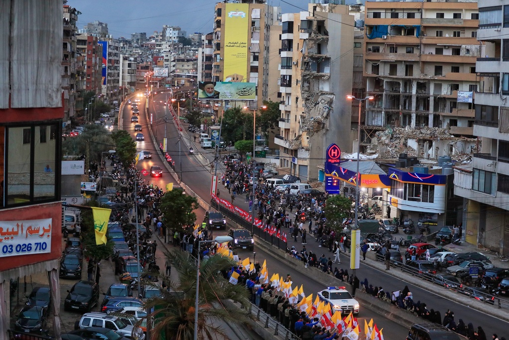 The convoy escorting Pope Leo XIV drives past war-damaged buildings in Beirut, Lebanon, Sunday, Nov. 30, 2025, following his arrival. (AP Photo/Mohammed Zaatari)