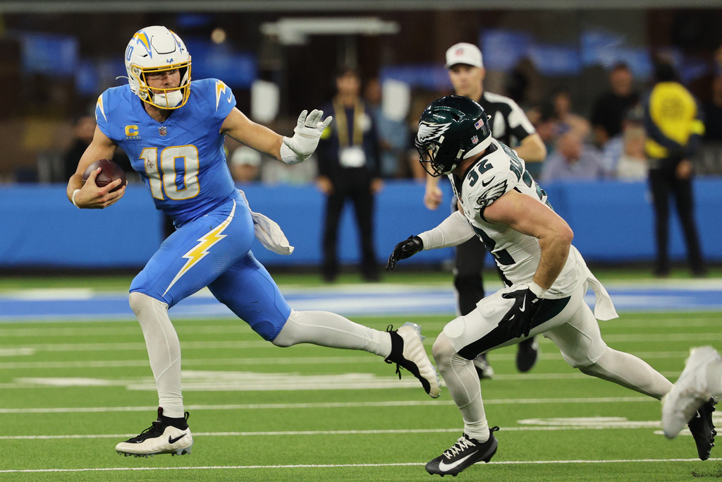 Los Angeles Chargers quarterback Justin Herbert (10) runs past Philadelphia Eagles safety Reed Blankenship (32) during overtime of an NFL football game Monday, Dec. 8, 2025, in Inglewood, Calif. (AP Photo/Kevork Djansezian)