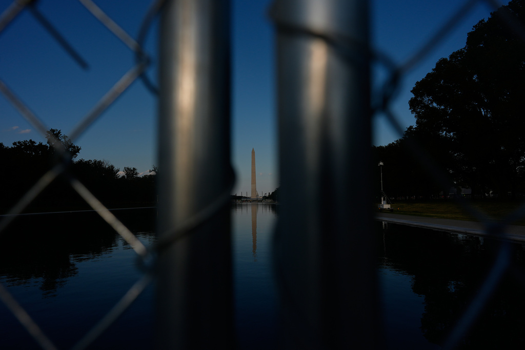 The Washington Monument, reflected in the Lincoln Memorial Reflecting Pool, is seen behind a chain link fence Thursday, June 25, 2026, in Washington. (AP Photo/Carolyn Kaster)