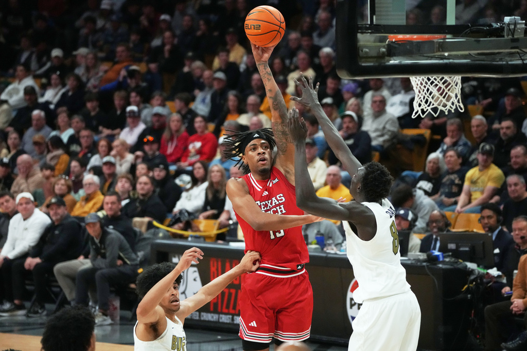 Texas Tech forward JT Toppin, center, goes up for a basket between Colorado guard Felix Kossaras, left, and forward Bangot Dak in the first half of an NCAA college basketball game, Saturday, Jan. 10, 2026, in Boulder, Colo. (AP Photo/David Zalubowski)