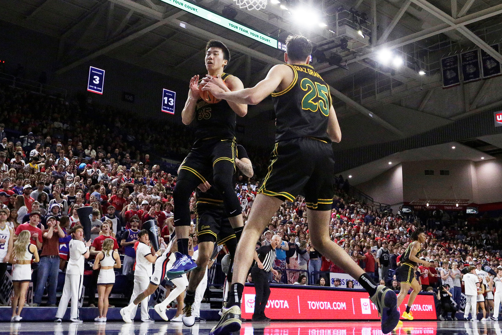 San Francisco forward Junjie Wang, center left, grabs a rebound next to teammate Guillermo Diaz Graham (25) during the first half of an NCAA college basketball game against Gonzaga, Saturday, Jan. 24, 2026, in Spokane, Wash. (AP Photo/Young Kwak)