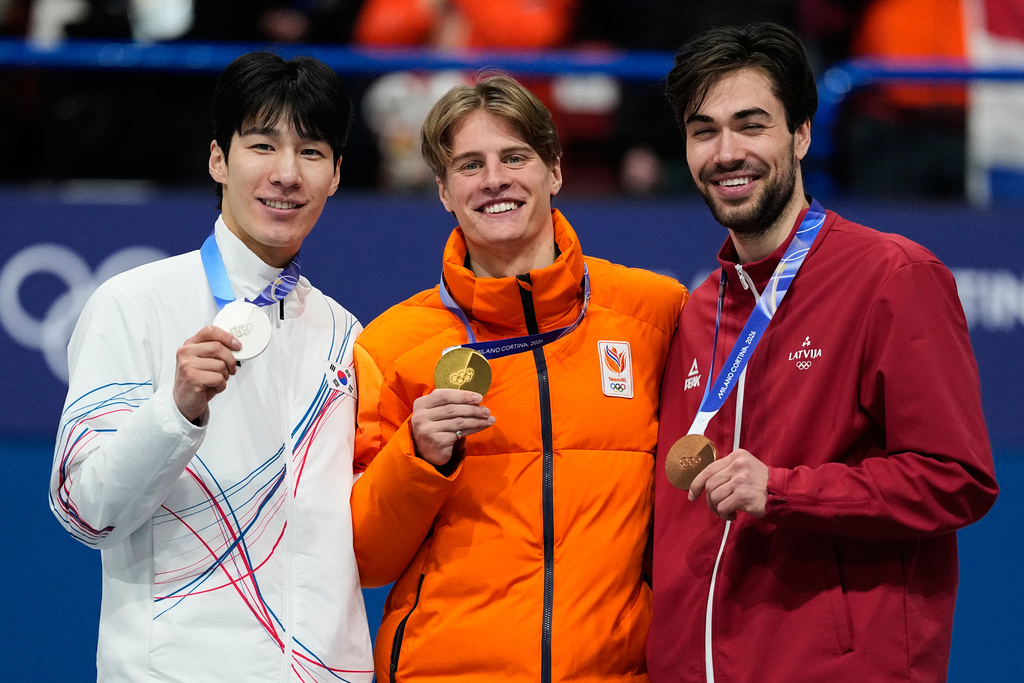 From left to right, silver medalist Hwang Daeheon of South Korea, gold medalist Jens van 't Wout of the Netherlands and bronze medalist Roberts Kruzbergs of Latvia receive their medals after the short track speed skating men's 1500m at the 2026 Winter Olympics, in Milan, Italy, Saturday, Feb. 14, 2026. (AP Photo/Ashley Landis)