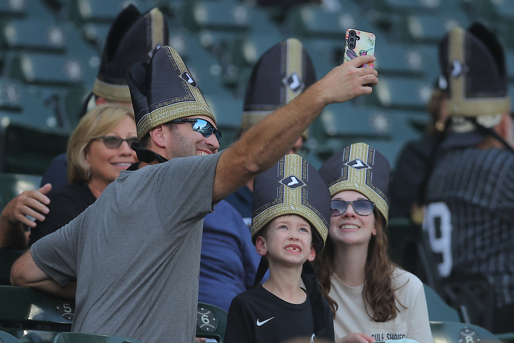 A group of fans wear a promotional pope hat prior to a baseball game between the Cincinnati Reds and Chicago White Sox, Tuesday, Aug. 11, 2026, in Chicago. (AP Photo/Melissa Tamez)