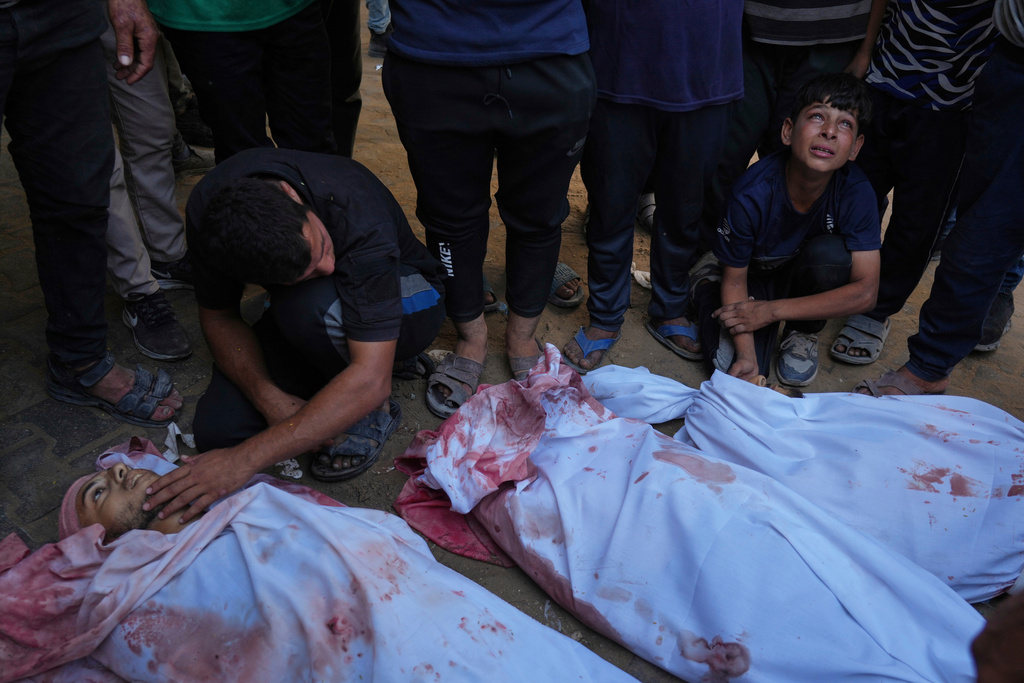 Young Palestinian Tariq Nasser, 12, right, mourns over the body of his brother Ayman Nasser, who was killed in an Israeli military strike, during his funeral outside Shifa Hospital in Gaza City, Sunday, Aug. 31, 2025. (AP Photo/Jehad Alshrafi)