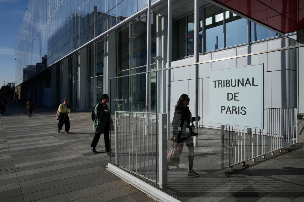 People walks in front of the Paris courthouse, in Paris, France, Monday, April 20, 2026. (AP Photo/Michel Euler)