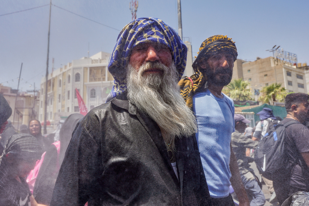 Water is sprayed over Shiite pilgrims to cool them as they make their way to Karbala for Arbaeen, the annual Shiite commemoration marking 40 days after Ashura, in Najaf, Iraq, Friday, July 31, 2026. (AP Photo/Ammar Khalil)