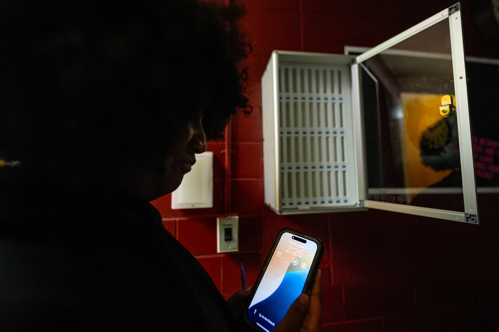FILE - A student views her cell phone at Ronald McNair Sr. High School, Aug. 7, 2025, in Atlanta. (AP Photo/Mike Stewart, File)