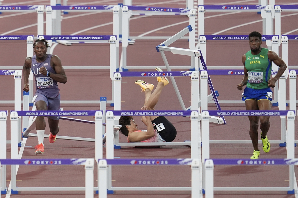 Japan's Shunsuke Izumiya, center, falls as United States' Dylan Beard and Brazil's Thiago Resende Ornelas Dos Santos compete in the men's 110 meters hurdles semifinal at the World Athletics Championships in Tokyo, Tuesday, Sept. 16, 2025. (AP Photo/Abbie Parr)