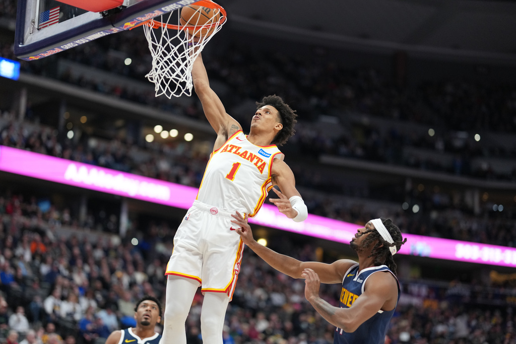 Atlanta Hawks forward Jalen Johnson, left, goes up for a basket as Denver Nuggets center DaRon Holmes defends in the first half of an NBA basketball game Friday, Jan. 9, 2026, in Denver. (AP Photo/David Zalubowski)