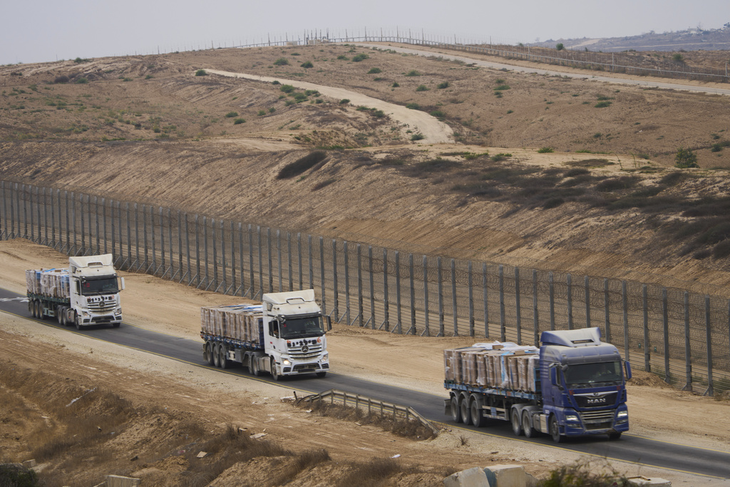 Trucks carrying humanitarian aid for Palestinians in Gaza move along the border with Gaza Strip in southern Israel, Wednesday, Aug. 13, 2025. (AP Photo/Ariel Schalit)