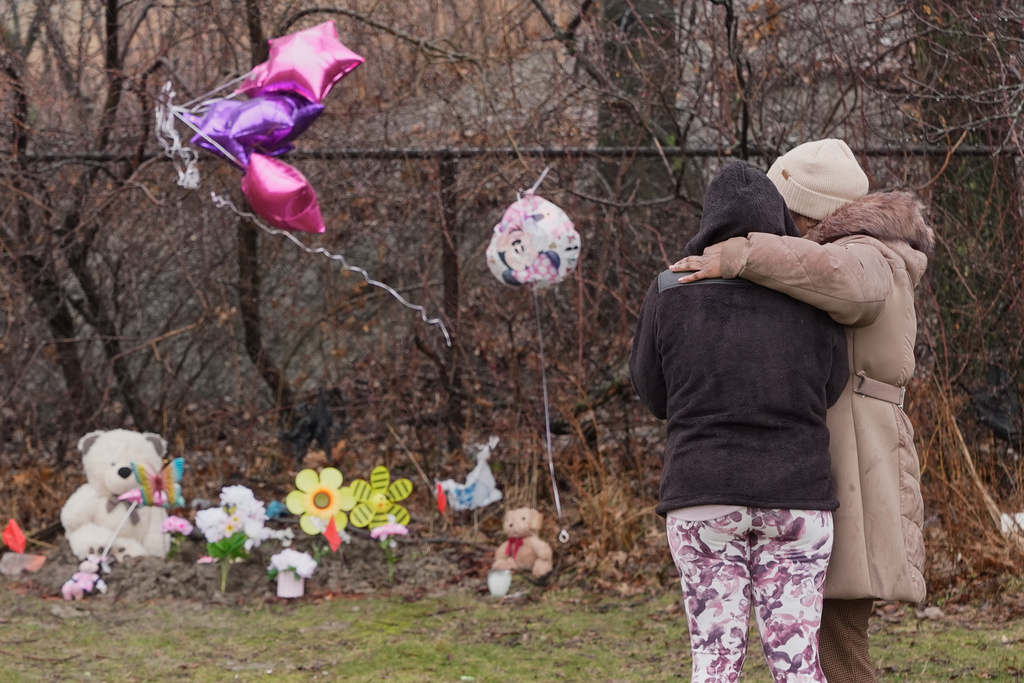 Nichelle Wilson, left, the grandmother of one of the girls whose bodies were found earlier this week, Amor Wilson, stands with her friend Sharon Hunter, right, at the site where a memorial is now, in Cleveland, Thursday, March 5, 2026. (AP Photo/Sue Ogrocki)