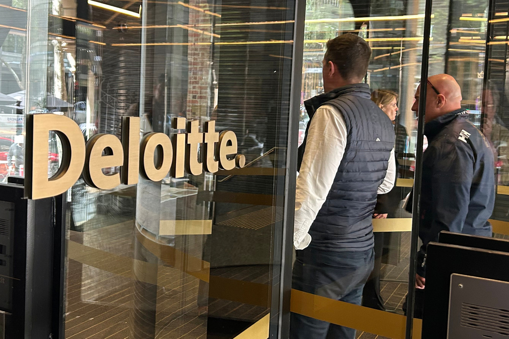 People arrive at the offices of Deloitte in Melbourne, Australia, on Tuesday, Oct. 7, 2025. (AP Photo/Rod McGuirk)