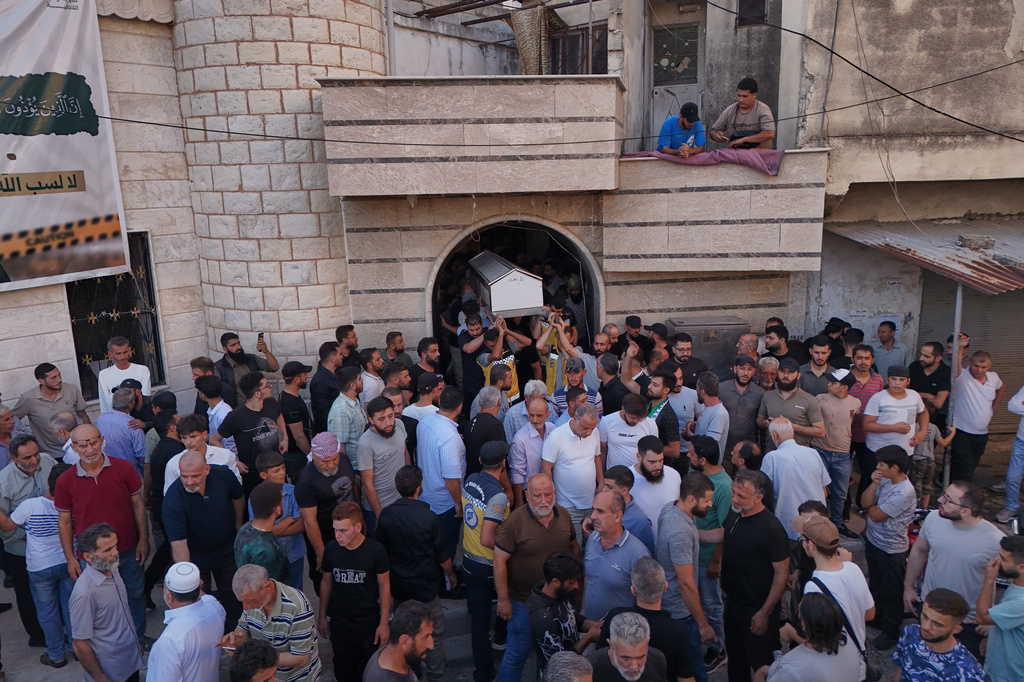 Mourners carry the coffin of Mohammad Ghamira, a former White Helmets volunteer who died shortly after his release from jail, for burial in the village of al-Haffa, in Latakia province, Syria, Monday, Aug. 17, 2026. (AP Photo)