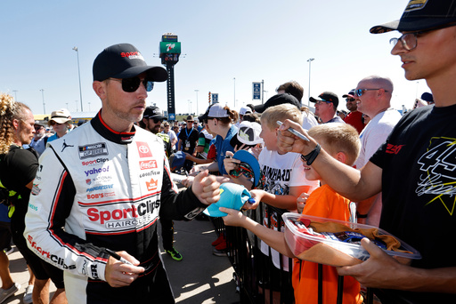 Denny Hamlin, left, gives autographs before a NASCAR Cup Series auto race at Kansas Speedway in Kansas City, Kan., Sunday, Sept. 28, 2025. (AP Photo/Colin E. Braley) Denny Hamlin, left, gives autographs before a NASCAR Cup Series auto race at Kansas Speedway in Kansas City, Kan., Sunday, Sept. 28, 2025. (AP Photo/Colin E. Braley)