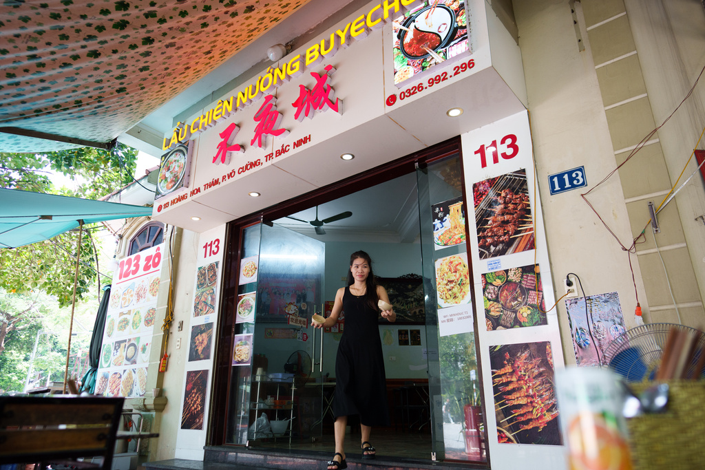 A Vietnamese restaurant staffer serves customers in downtown Bac Ninh, Vietnam, Nov. 3, 2025. (AP Photo/Vincent Thian)