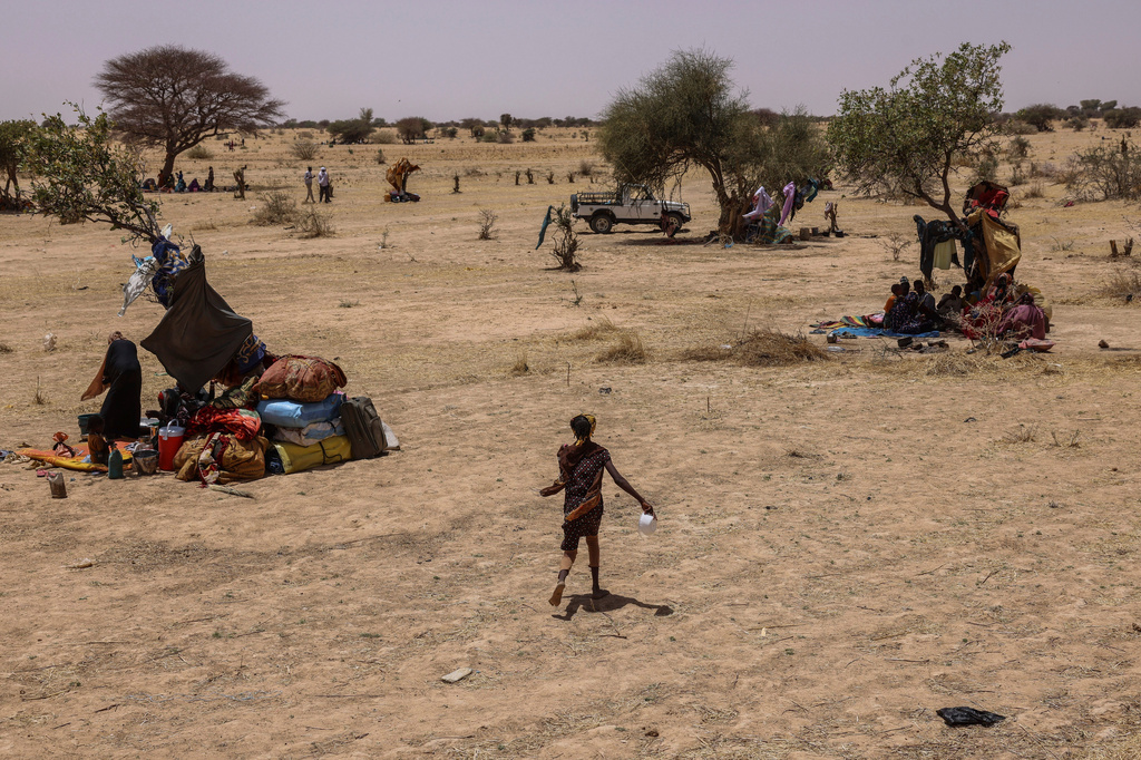 FILE - Refugees run for food in the Tine transit camp in Chad's Wadi Fara province on May 4, 2025. (AP Photo/Caitlin Kelly, File)