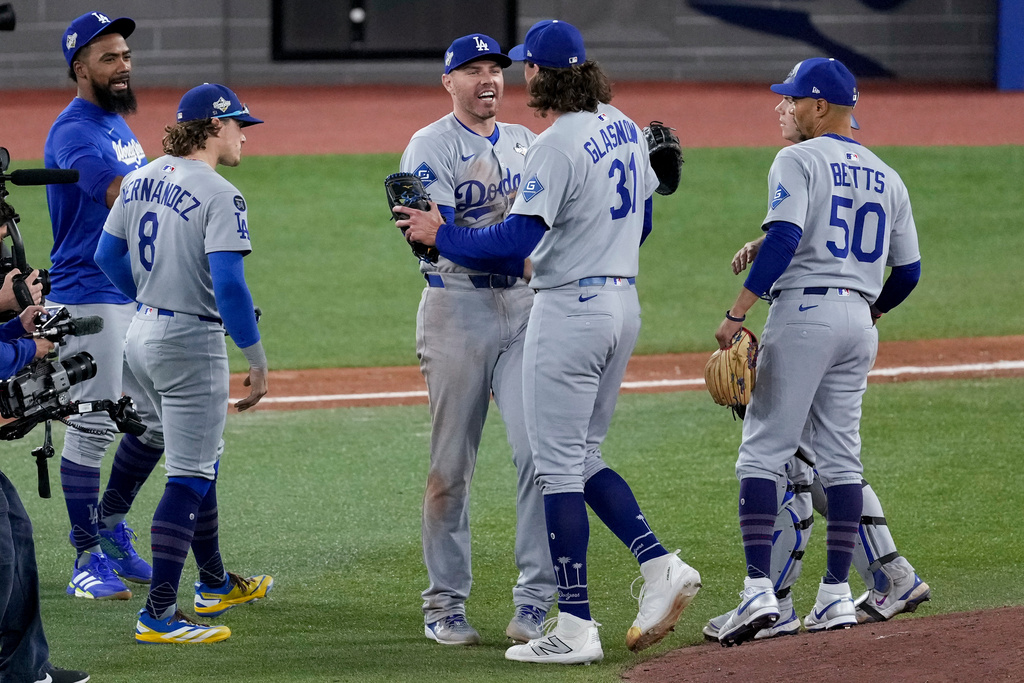 Los Angeles Dodgers' Mookie Betts (50), Tyler Glasnow (31), Freddie Freeman and Kiké Hernández (8) celebrate after Game 6 of baseball's World Series against the Toronto Blue Jays, Friday, Oct. 31, 2025, in Toronto. (AP Photo/Ashley Landis)