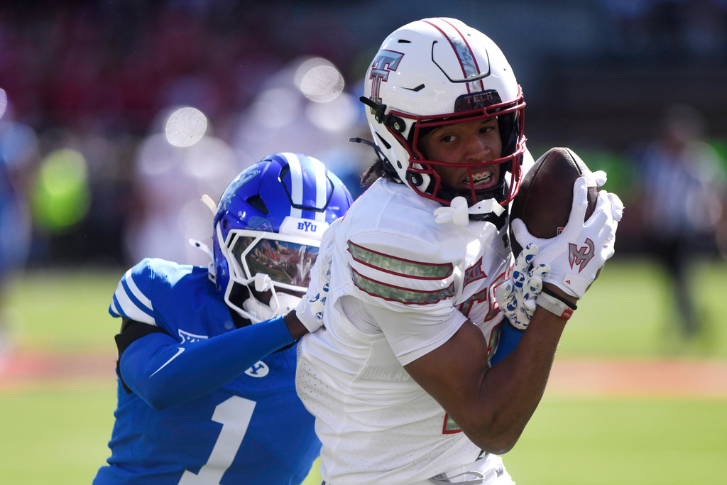 Texas Tech wide receiver Reggie Virgil (1) catches a pass ahead of BYU cornerback Therrian Alexander III (1) during the first half of an NCAA college football game, Saturday, Nov. 8, 2025, in Lubbock, Texas. (AP Photo/Annie Rice)