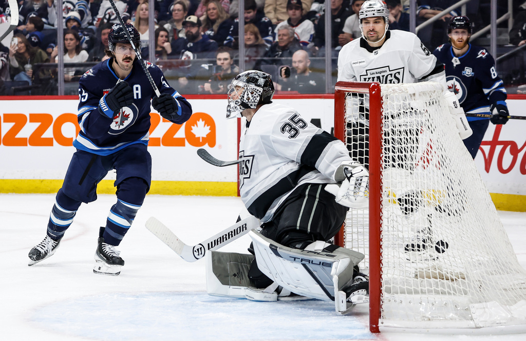 Winnipeg Jets' Mark Scheifele, left, scores against Los Angeles Kings goaltender Darcy Kuemper (35) during second-period NHL hockey game action in Winnipeg, Manitoba, Friday, Jan. 9, 2026. (John Woods/The Canadian Press via AP)