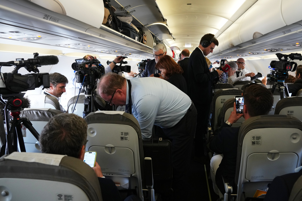 Journalists attend into the papal flight after takeoff was delayed at Los Rodeos International Airport, at the Canary Islands, Spain, Friday, June 12, 2026. (AP Photo/Alessandra Tarantino)